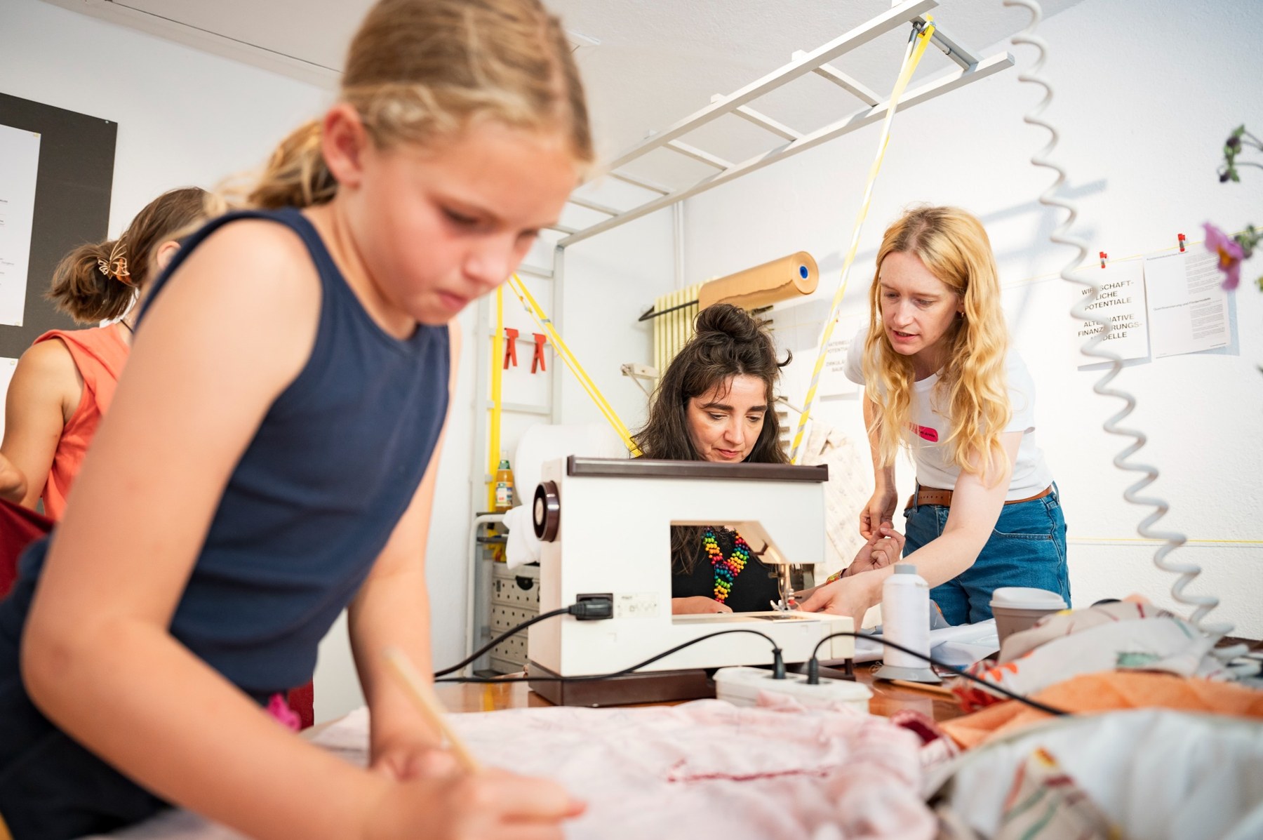 Participants cutting and sewing fabric during a workshop in Überlingen